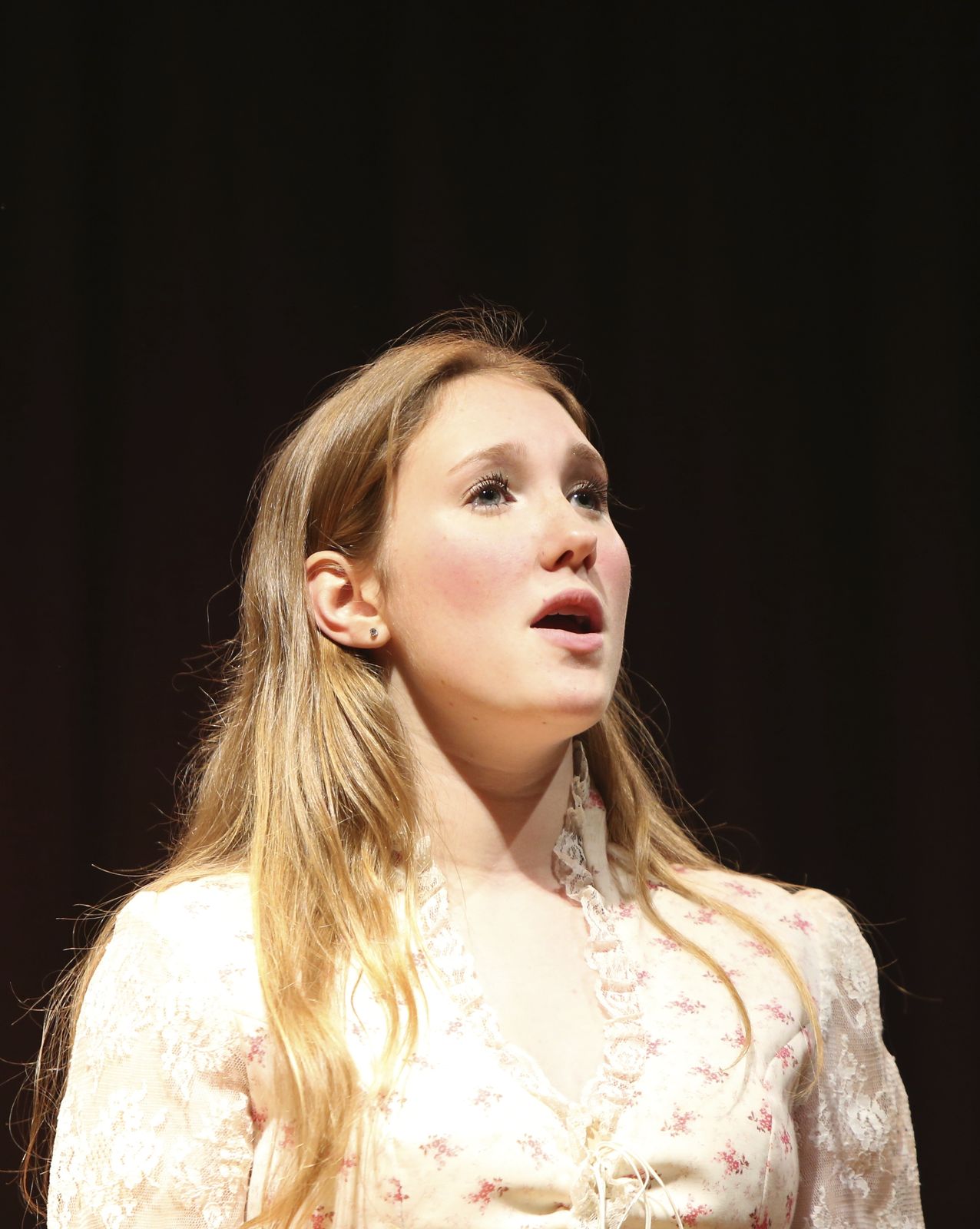 A young performer singing in Oklahoma!